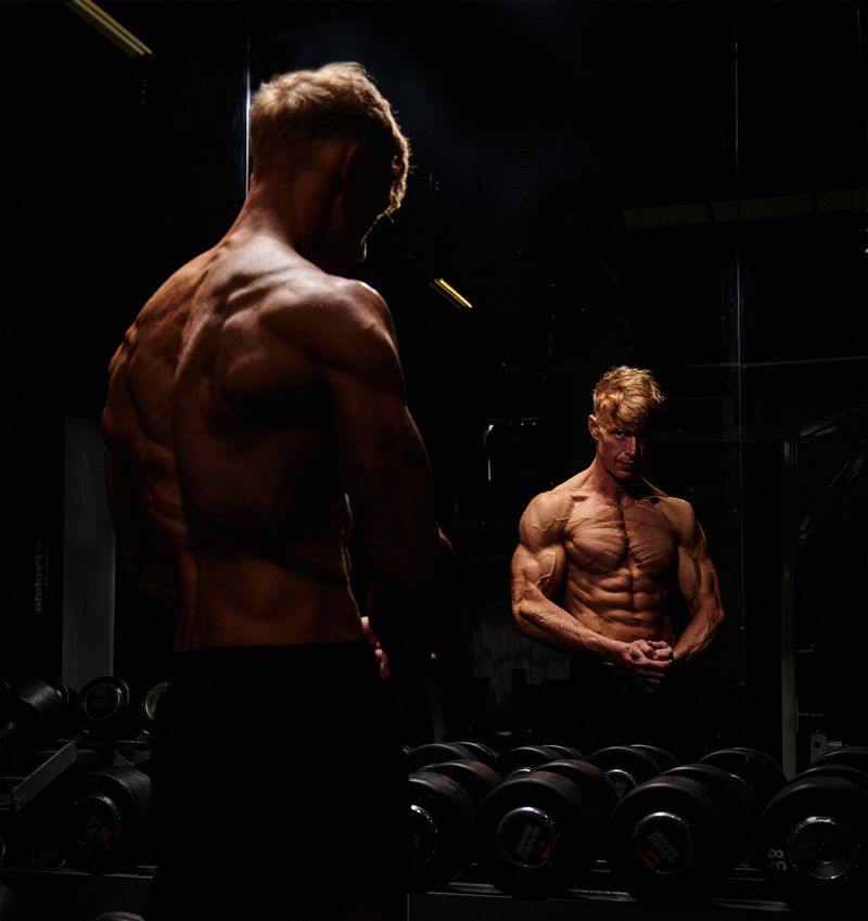Vincent van achteren bij de spiegel in de sportschool, geconcentreerd voor het trainen